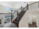 Elegant staircase with dark wood steps, black iron railings, and a view of the pool area through clerestory windows at 4959 Tennessee Lake Dr, Auburndale, FL 33823