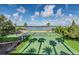 This aerial shot shows a tennis and basketball court next to Lake Juliana, shaded by palms and featuring a gazebo at 4959 Tennessee Lake Dr, Auburndale, FL 33823