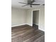 Image displays a bedroom with a ceiling fan, wood-look floors, and neutral walls at 521 Tennessee Ave, St Cloud, FL 34769