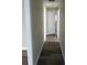 Long hallway features laminate flooring, neutral paint and doors leading to bedrooms and bathrooms at 521 Tennessee Ave, St Cloud, FL 34769