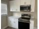 Modern kitchen showcasing stainless steel appliances, white cabinets, and sleek countertops at 521 Tennessee Ave, St Cloud, FL 34769