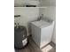 Bright laundry area featuring a washing machine, water heater, and ample shelving space for storage at 521 Tennessee Ave, St Cloud, FL 34769