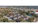 An aerial view shows well-maintained community homes near a pond, mature trees, shopping and commercial businesses at 5360 Diplomat Ct # 107, Kissimmee, FL 34746