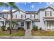 Charming townhouse features a well-manicured lawn, palm tree, and inviting entryway at 5360 Diplomat Ct # 107, Kissimmee, FL 34746