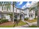 A townhouse boasts mature landscaping, a palm tree, and a welcoming front entrance at 5360 Diplomat Ct # 107, Kissimmee, FL 34746