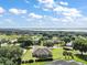 Beautiful aerial view showcasing a home with a vast green landscape and serene lake backdrop at 5701 Crestview Dr, Lady Lake, FL 32159