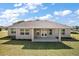 Home's rear exterior showcases a covered patio, large windows, and pristine landscaping at 5701 Crestview Dr, Lady Lake, FL 32159