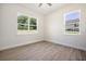 Bedroom with wood-look tile floors, ceiling fan, and dual windows at 5701 Crestview Dr, Lady Lake, FL 32159