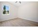 Empty bedroom with wood-look tile floors and large windows overlooking the yard at 5701 Crestview Dr, Lady Lake, FL 32159