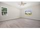 Bright bedroom featuring wood-look tile floors, a ceiling fan, and dual windows at 5701 Crestview Dr, Lady Lake, FL 32159