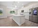 Kitchen featuring a large island with seating, stainless steel appliances, and white cabinetry at 5701 Crestview Dr, Lady Lake, FL 32159