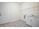 Functional laundry room with stylish tile flooring, utility sink, and convenient storage shelves at 5701 Crestview Dr, Lady Lake, FL 32159