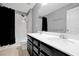 Bathroom features a double sink vanity with dark cabinetry, a shower with black curtain, and ample lighting at 580 Seattle Slew Dr, Davenport, FL 33837
