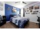 Well-lit bedroom with blue accent wall, ceiling fan, and nature-themed decor at 580 Seattle Slew Dr, Davenport, FL 33837