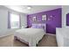 Bedroom with purple accent wall, window with blinds, desk, and fluffy white bedspread at 580 Seattle Slew Dr, Davenport, FL 33837