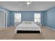 This bedroom features neutral walls and carpet, with two large windows and white nightstands at 580 Seattle Slew Dr, Davenport, FL 33837