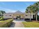 View of the community center featuring a gated entrance, stone accents, and a well-manicured lawn at 580 Seattle Slew Dr, Davenport, FL 33837