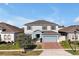 Charming two-story home with a well-manicured lawn and a brick-paved driveway at 580 Seattle Slew Dr, Davenport, FL 33837