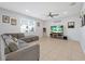 Bright living room with tile floors, large window, and a comfortable gray sectional sofa at 580 Seattle Slew Dr, Davenport, FL 33837
