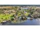 Aerial view of a property featuring a lake, dock, and lush greenery in a serene neighborhood at 6845 Old Melbourne Hwy, St Cloud, FL 34771