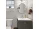 Bathroom featuring a vanity with sink, toilet, oval mirror, and a window at 6845 Old Melbourne Hwy, St Cloud, FL 34771