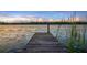 Picturesque lake view showcasing a wooden dock surrounded by lily pads and reeds, perfect for nature lovers at 6845 Old Melbourne Hwy, St Cloud, FL 34771