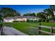 Charming single-story home with a manicured lawn and a welcoming gated entrance at twilight at 6845 Old Melbourne Hwy, St Cloud, FL 34771