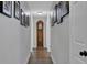 Long hallway with hardwood flooring, framed art, and a grandfather clock as a focal point at 6845 Old Melbourne Hwy, St Cloud, FL 34771