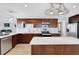 A kitchen featuring dark wood cabinetry, stainless steel appliances, and a white countertop island at 6845 Old Melbourne Hwy, St Cloud, FL 34771