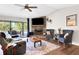 Comfortable living room with a stone fireplace, vaulted ceiling, and sliding glass doors at 6845 Old Melbourne Hwy, St Cloud, FL 34771