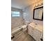 Updated bathroom featuring a tiled walk-in shower with glass and a modern vanity with white cabinets at 708 Se Pine Ave, Fort Meade, FL 33841