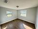 Bedroom featuring wood flooring and natural light from two windows at 708 Se Pine Ave, Fort Meade, FL 33841