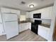 Kitchen featuring white cabinets, granite countertops, and black appliances at 708 Se Pine Ave, Fort Meade, FL 33841