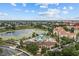 Aerial view showcasing the community pool, waterpark, and surrounding residential area and pond at 7671 Comrow St # 303, Kissimmee, FL 34747