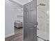 Bathroom with a frameless glass shower door, gray walls, and tile flooring at 7671 Comrow St # 303, Kissimmee, FL 34747