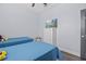 Bedroom featuring two twin beds with blue bedding, a white dresser and grey wood floors at 7671 Comrow St # 303, Kissimmee, FL 34747