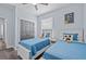 Cozy bedroom with twin beds featuring cartoon character dolls and grey wood flooring at 7671 Comrow St # 303, Kissimmee, FL 34747