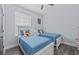 Bright bedroom featuring twin beds with blue bedding, light walls, and grey wood floors at 7671 Comrow St # 303, Kissimmee, FL 34747