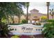 Windsor Hills Clubhouse entrance with lush landscaping and a stately sign that welcomes residents and guests at 7671 Comrow St # 303, Kissimmee, FL 34747