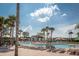 Lounge by the community pool under palm trees, offering a relaxing and picturesque setting for residents at 7671 Comrow St # 303, Kissimmee, FL 34747