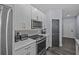 Modern kitchen with stainless steel appliances, white cabinets, and a stylish herringbone backsplash at 7671 Comrow St # 303, Kissimmee, FL 34747
