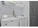 Laundry room with white washer and dryer and wire storage rack above at 7671 Comrow St # 303, Kissimmee, FL 34747