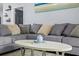 A comfortable gray sectional sofa with decorative pillows arranged around an oval coffee table at 7671 Comrow St # 303, Kissimmee, FL 34747