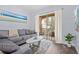 Bright living room featuring a comfortable gray sectional sofa and a sliding glass door to the balcony at 7671 Comrow St # 303, Kissimmee, FL 34747