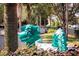 Whimsical dragon themed playground with green sculpture amidst mature trees and greenery at 7671 Comrow St # 303, Kissimmee, FL 34747