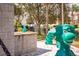 Playground with green dragon structure, situated among mature trees and landscaping at 7671 Comrow St # 303, Kissimmee, FL 34747