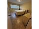 Bedroom featuring tiled floors, a large window with blinds and neutral paint at 777 W Lancaster Rd # A-13, Orlando, FL 32809
