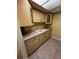 A kitchen featuring light wood cabinets, neutral countertops, and tan tiled flooring at 777 W Lancaster Rd # A-13, Orlando, FL 32809