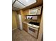 A kitchen featuring light wood cabinets, neutral countertops, and white appliances including a range and refrigerator at 777 W Lancaster Rd # A-13, Orlando, FL 32809