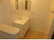 Modest bathroom with a single sink vanity, mirror, and toilet, all in a neutral color palette at 84 Silver Park Cir, Kissimmee, FL 34743